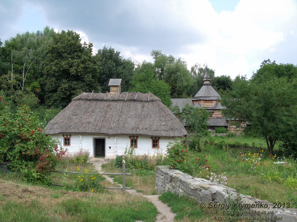Фото Киева. Музей народной архитектуры и быта Украины. Побеленная деревянная хата с соломенной крышей из села Луга на Подолье. Зона "Подолье и Восточная Полтавщина".
