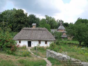 Фото Киева. Музей народной архитектуры и быта Украины. Побеленная деревянная хата с соломенной крышей из села Луга на Подолье.
Зона "Подолье и Восточная Полтавщина".