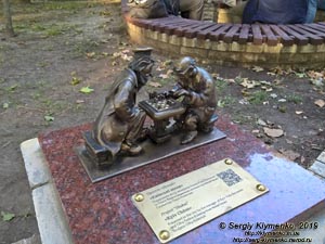 Фото Киева. Миниатюрный памятник «Киевские шахматы» (проект «Шукай!») возле беседки на шахматной площадке невдалеке от фонтана в парке им. Тараса Шевченко.