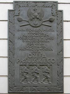 Фото Кракова. Памятная доска с информацией об изменении названия улицы Вольская (Wolska) на Юзефа Пилсудского (Józefa Piłsudskiego).