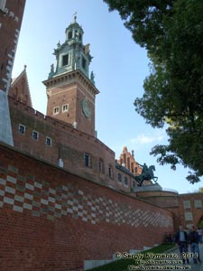 Фото Кракова. Вавель (Wawel). Стена с кирпичами с именами дарителей и Часовая башня (Wieża Zegarowa), вид со стороны подъезда к Гербовым воротам.